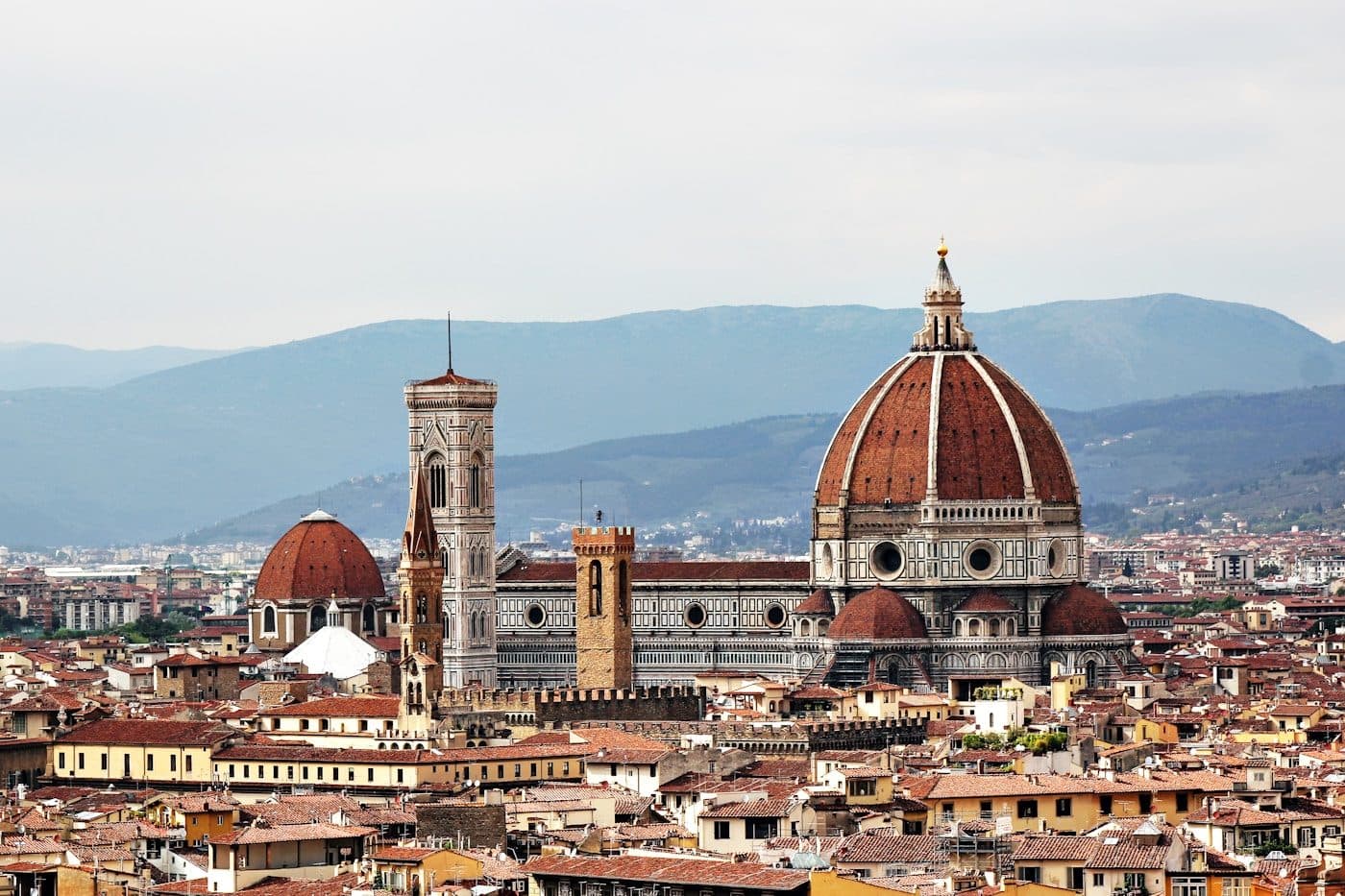 Detail of the marble façade and dome of Florence Cathedral seen from the square below