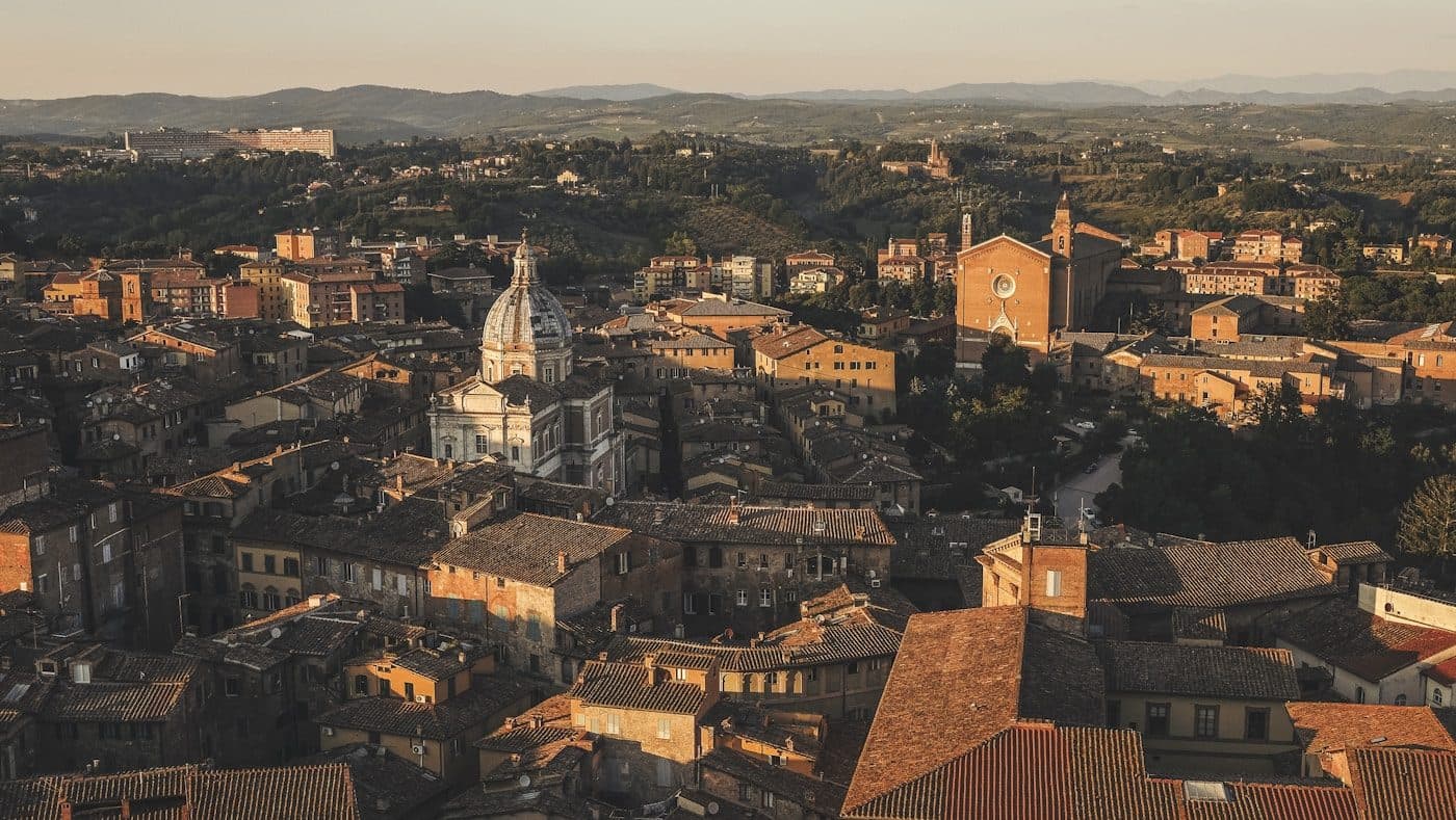 Aerial view over the medieval rooftops of Siena with the cathedral and the Torre del Mangia