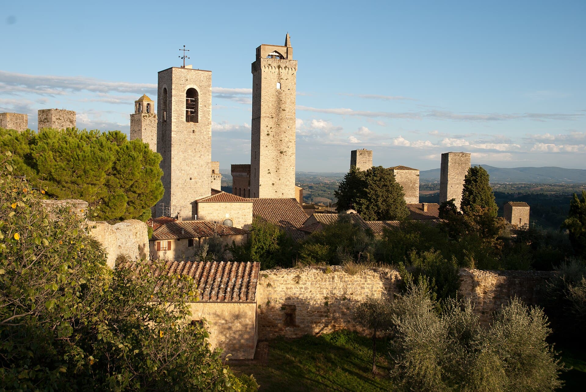 The medieval tower houses of San Gimignano rising above the town walls at golden hour